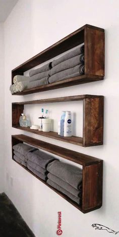 two wooden shelves holding towels and other bathroom items