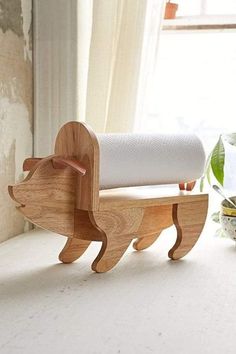 a wooden toy animal with a roll of toilet paper on it's back