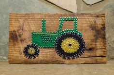 a wooden sign with a tractor painted on it's side and beaded details