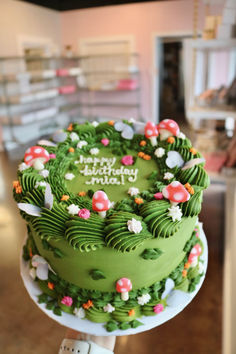 a green birthday cake sitting on top of a table