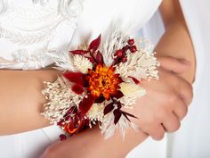 a close up of a person wearing a white dress and holding a flower bouquet in their hand