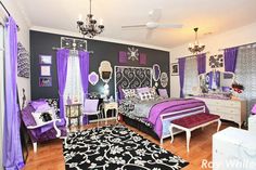 a bedroom with purple and black decor on the walls