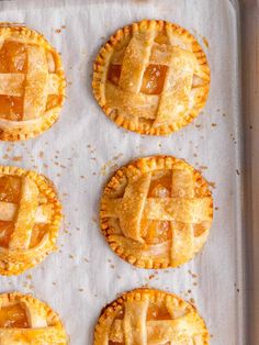 six pies on a baking sheet ready to be baked in the oven for dessert