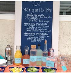 there is a sign that says margarita bar on the table with drinks and condiments