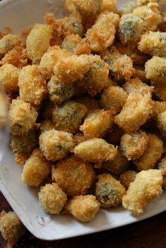 a white plate topped with fried food on top of a wooden table