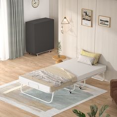 a white bed sitting on top of a wooden floor next to a wall mounted clock