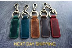 six leather key fobrings in different colors on a wooden table with text next day shipping