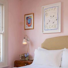 a bedroom with pink walls and white bedding