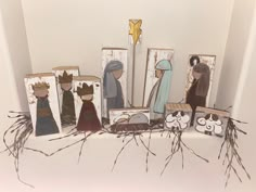 nativity scene displayed on white surface with candlesticks and paper cutout figurines