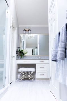 a white bathroom with a vanity and mirror