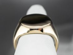 This vintage unisex signet ring has a modest profile on the hand and is completely un-decorated. These features make it versatile, and an easy gift to give, and an easy ring to wear day-to-day. Market Square Jewelers works with one of the finest hand engravers in the northeast. With over 30 years of experience, our engraver hand carves lettering, monograms, crests, or patterns in period-specific styles. Choose from our many monogram options shown in the listing or contact us directly with your own crest, monogram, or for additional information, and pricing! Metal: 14K Yellow Gold Top Measurements: 19 x 16 mm, Oval Ring Size: 9.25 Marks: “14K” Stamped on the inside band Elegant Engraved Formal Ring, Modern Domed Signet Ring For Gift, Modern Domed Signet Ring As Gift, Domed Signet Ring With Polished Finish For Gift, Elegant Rounded Formal Signet Ring, Elegant Formal Rounded Signet Ring, Elegant Formal Signet Ring, Modern Signet Ring With Round Band For Formal Occasions, Luxury Domed Signet Ring For Formal Occasions