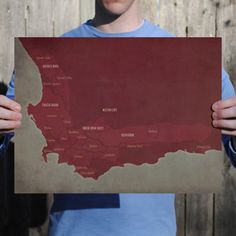 a young man holding up a map of the united states in front of his face