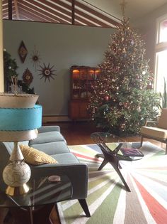 a living room filled with furniture and a christmas tree in the middle of the room