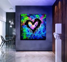 an abstract painting in the shape of a heart on a wall next to a dining room table