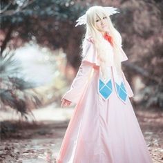 a woman in a long pink dress is walking through the woods