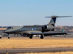 an airplane that is sitting on the ground in front of some grass and dirt area