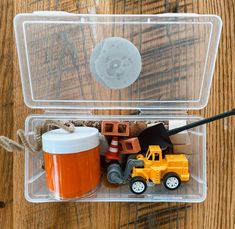 a plastic container filled with toys on top of a wooden table