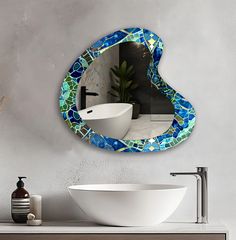 there is a sink and mirror in the bathroom with it's blue mosaic design