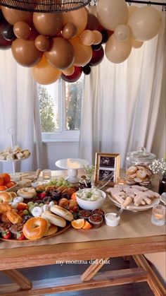 a table filled with lots of food and balloons