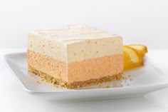 a piece of cake on a white plate with orange slices around it and some sugar sprinkles