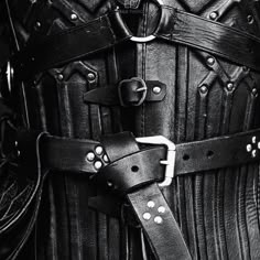 the belt is made from black leather and has metal buckles on it, which are attached