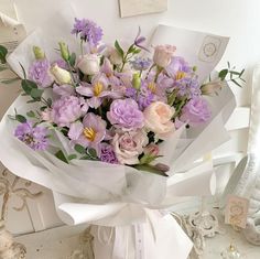 a bouquet of flowers sitting on top of a table next to a white box with an envelope