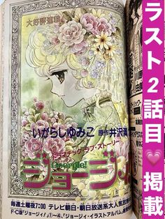 an open book with japanese writing and flowers on it's cover, in front of a blue sky