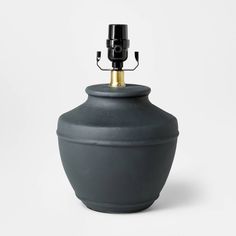 a black vase with a gold top on a white background