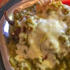 a close up of a plate of food with cheese and green beans on the side