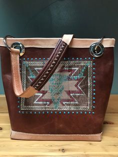 "Hand bead work inlayed in a medium brown and natural colored hand made leather purse. The bead work is a southwest design featuring a turquoise colored longhorn with the whole beaded pattern framed by turquoise spots. The lining of the purse is a gorgeous turquoise and brown paisley fabric which has a zippered pocket on one side and 2 open pockets on the opposite. Also included in the interior of the bag is a  a 'key leash' so as not to lose your keys. Magnetic closure and topped off with a sin Scarf Cuff, Bling Purses, Turquoise And Brown, Hand Made Leather, Brown Paisley, Southwest Design, Bag Obsession, Flower Scarf, Paisley Fabric