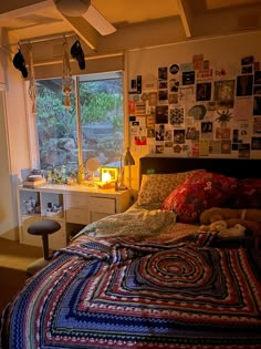 a bed room with a neatly made bed and lots of pictures on the wall above it