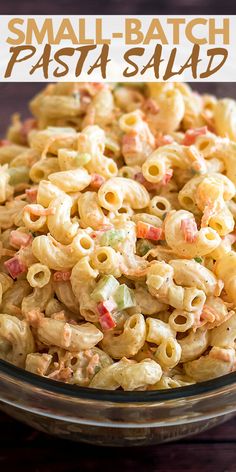 a bowl filled with pasta salad on top of a wooden table