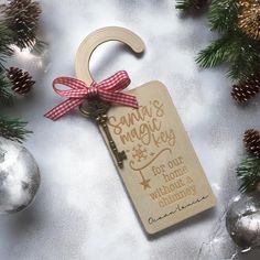 a wooden keychain with a christmas message hanging from it's side next to ornaments