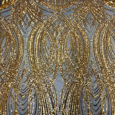 gold sequins and beads on a blue fabric with an intricate design in the center