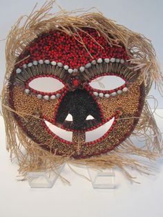 a mask is made out of straw and decorated with beads