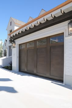 a house with two garage doors on the outside and one door open to let in light