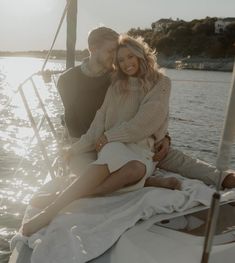 a man and woman sitting on the back of a boat