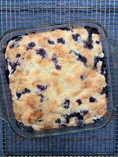 a blueberry cobbler in a glass baking dish on a cooling rack, ready to be eaten