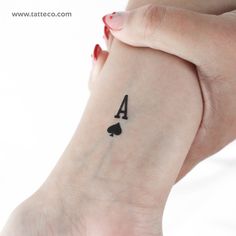 a woman's hand with a four card tattoo on her left wrist and the number 4 in black ink