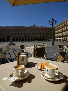 two cups of coffee sit on an outdoor table