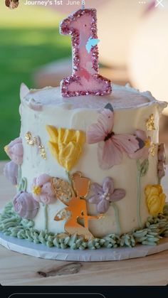 a birthday cake decorated with flowers and a number one on it's icing