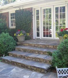 an outdoor patio with steps leading up to the front door