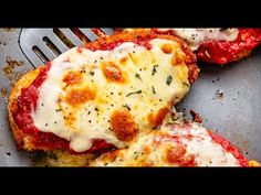 two pieces of pizza sitting on top of a pan covered in cheese and sauce next to a fork