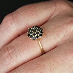 a woman's hand with a ring on it that has black and white stones