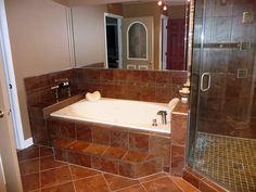 a bath tub sitting inside of a bathroom next to a walk in shower