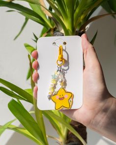 a person holding up a phone case with a star charm on it