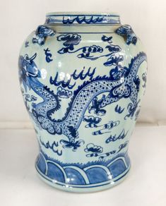 a blue and white vase sitting on top of a table next to a white wall