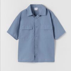 Zara Technical Nylon Shirt Blue - Size: Available In 13-14 Years In Kid's Size ( Equivalent To Size Xs In Women's) - Color: Blue - Materials: 71% Nylon, 29% Cotton. - Technical Nylon Shirt With Lapel Collar And Short Sleeves. - Front Snap Button Closure. - Front Flap Pockets. Blue Short Sleeve Tops With Pockets, Blue Relaxed Fit Short Sleeve Shirt For Spring, Blue Relaxed Fit Tops With Pockets, Casual Blue Shirt With Pockets, Zara Light Blue Collared Top, Casual Blue Tops With Pockets, Zara Solid Color Shirt For Summer, Zara Shirt For Summer, Blue Collared Short Sleeve Shirt With Pockets