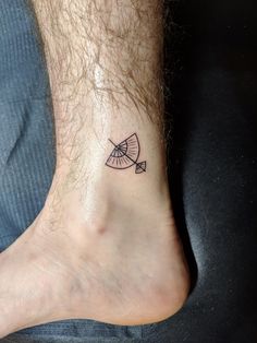 a small tattoo on the foot of a man with a bow and arrow in it