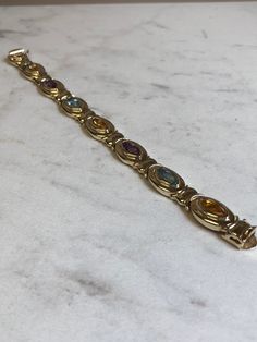 "14kt Yellow Gold Lady's Semi-Precious Multi Color Bracelet in 7\" consisting of 7- 11mm x 5mm Marquise Shape Semi-Precious Genuine Gemstones. Semi-Precious Gemstones include 3- Citrine, 2- Amethyst and 2- Blue Topaz all bezel set by our Master Goldsmith in a solid hinged 1/2\" wide bracelet with a large solid box clasp and a fig 8 safety clasp closure. Total weight of Bracelet is 33.0 grams. This item would Retail for $3,950.00" Heirloom Gold Bracelets With Multi-stone, Classic Yellow Gold Multi-stone Bracelets, 14k Yellow Gold Multi-stone Bracelet, Heirloom Gold Multi-stone Bracelets, Luxury Multicolor Multi-stone Gold Bracelet, Wide Bracelet, Gold Hoop, Colorful Bracelets, Gold Hoop Earrings